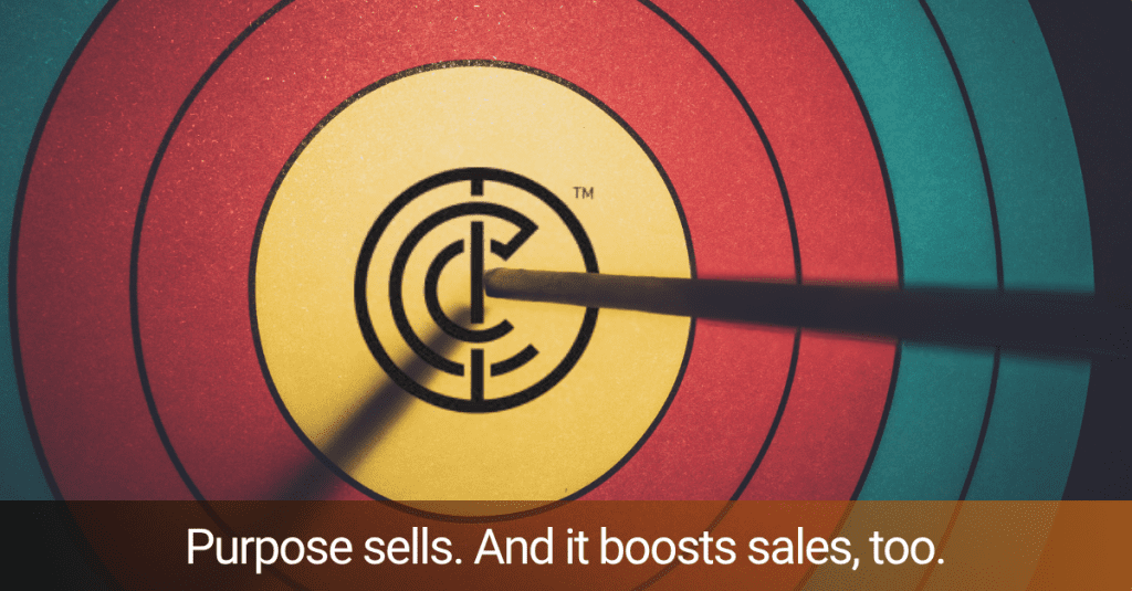 A close up view of a target with an arrow hitting the bullseye which is the Investors in Community symbol. Along the bottom is a black and orange gradient with the words "Purpose sells. And it boosts sales, too